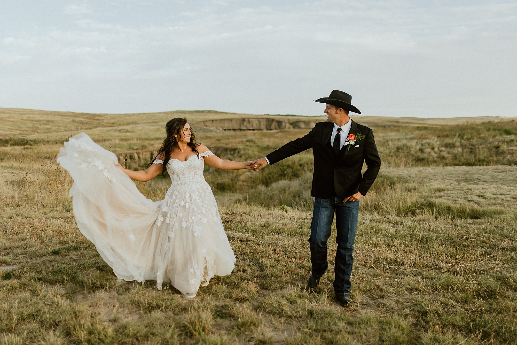 bride and groom in meadow show how not to feel awkward in photos groom has on cowboy hat