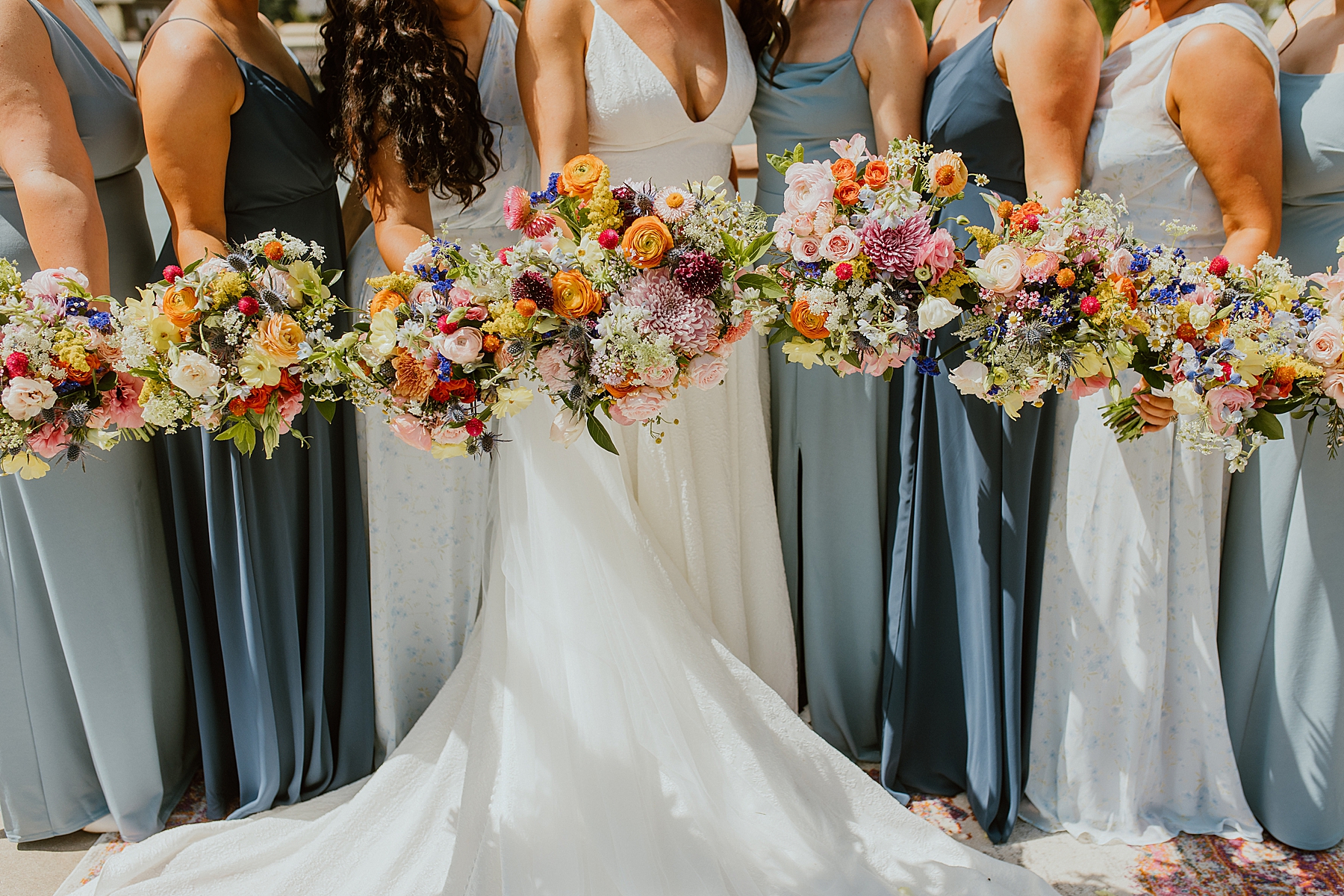 wedding day blooms wedding party holds out their bouquets