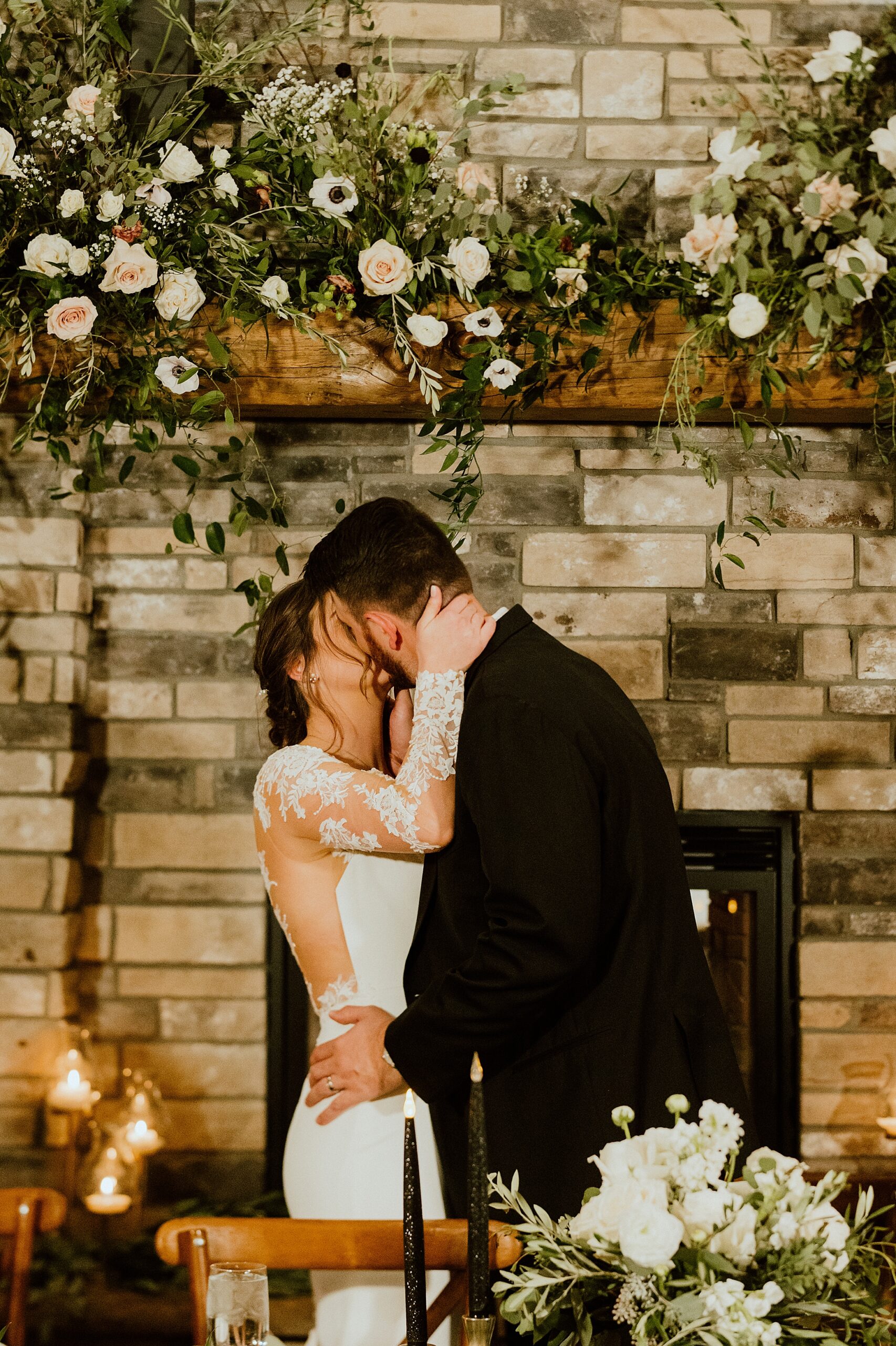 epic wedding photos involve smart placement of head table, florals, and lighting as bride and groom share head table kiss
