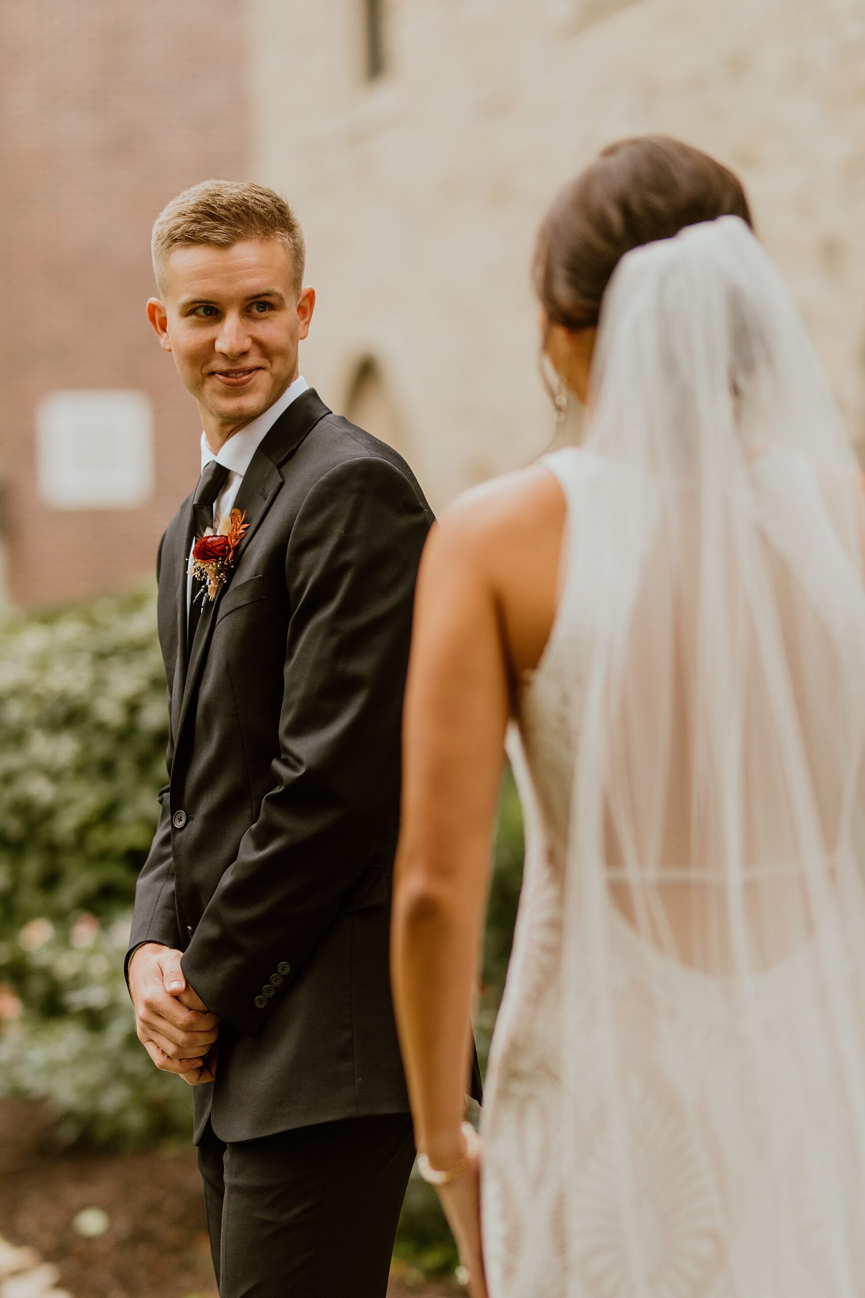 capture emotion in wedding photo as groom sees bride for first time. white dress white veil.