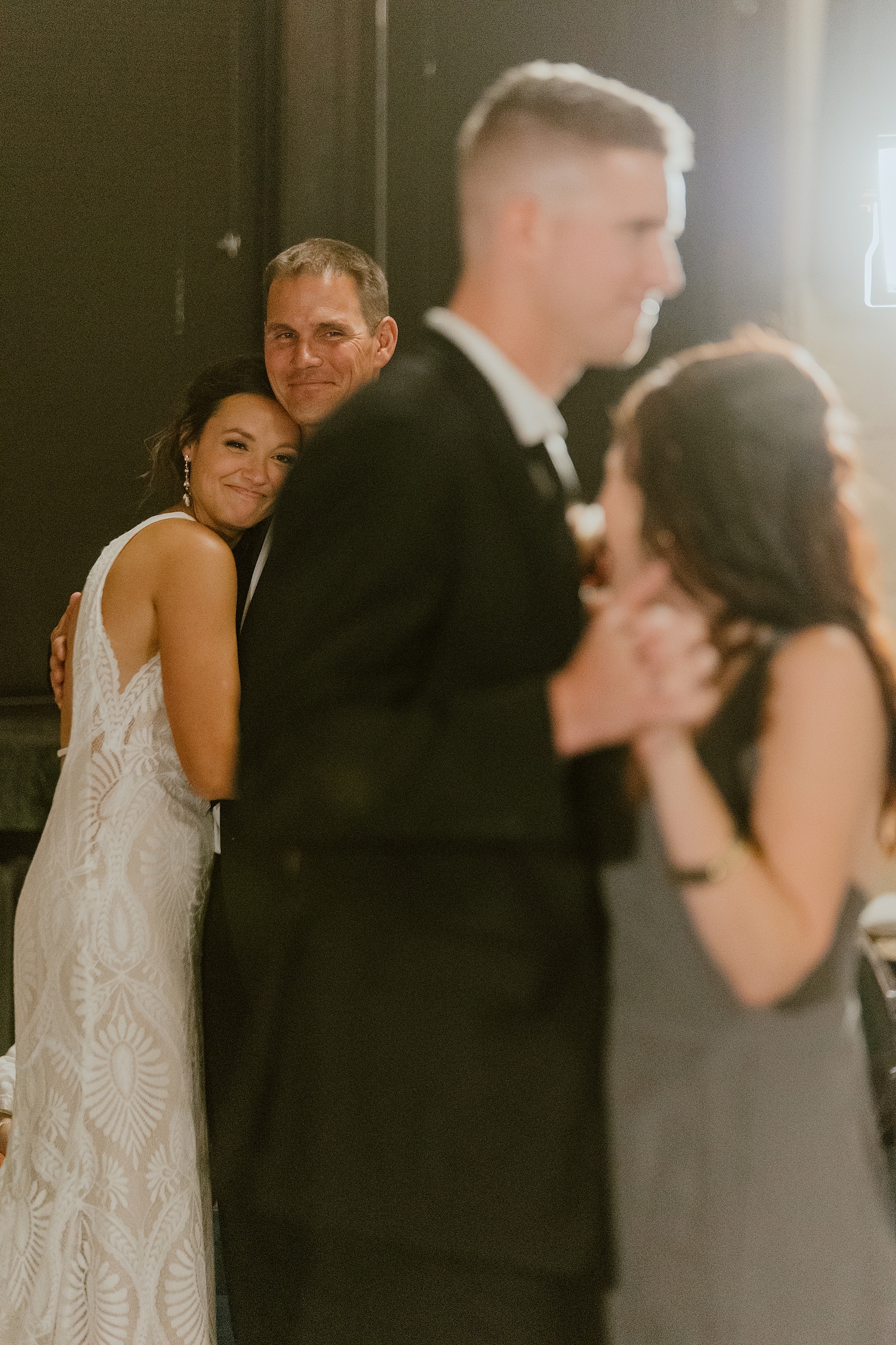 see emotions on bride's face as she dances with her dad while her mom looks on dancing with groom