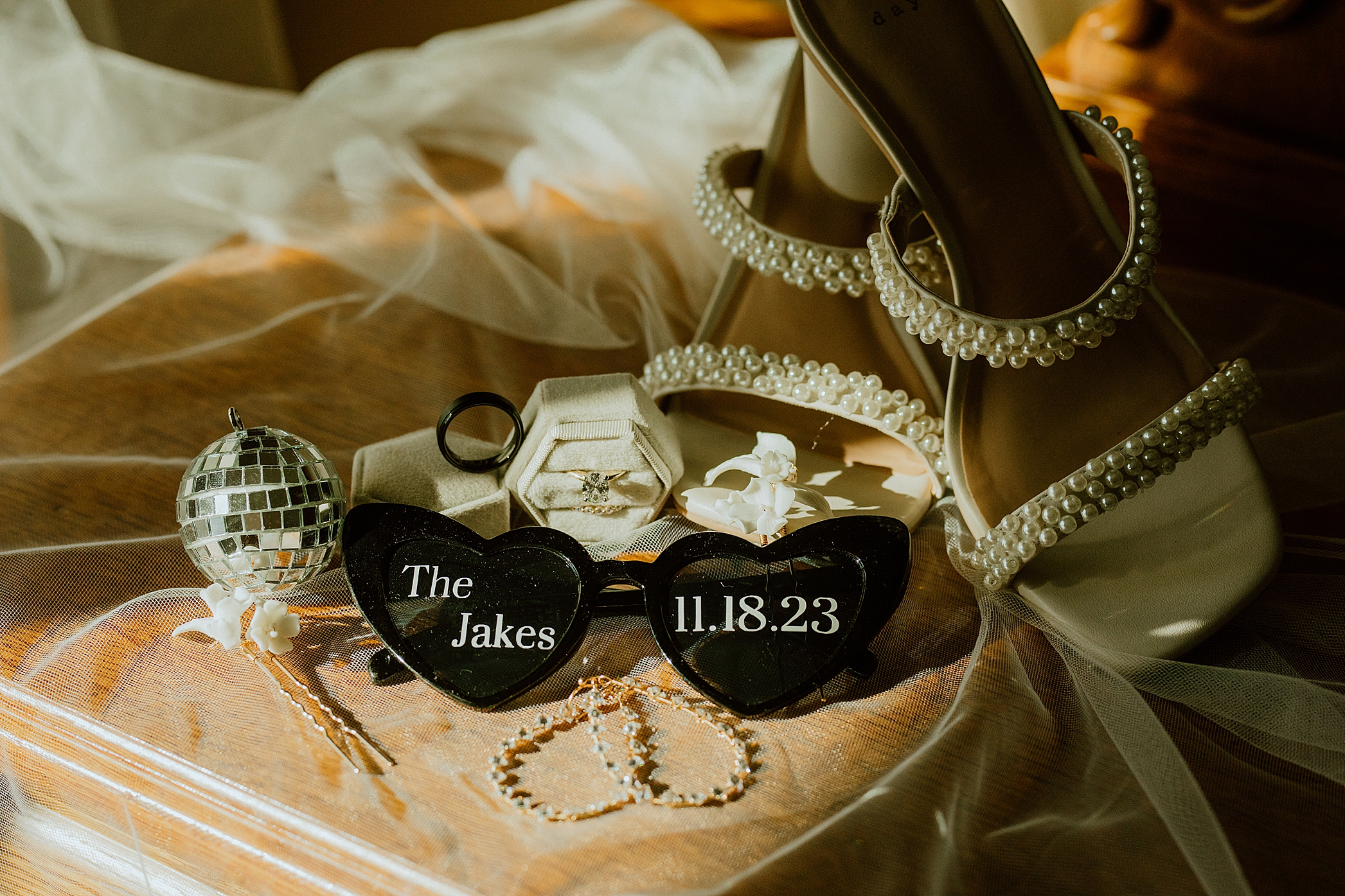 wedding photographer lays out wedding items from the special for a great memory in their wedding album: shoes, rings, date, veil