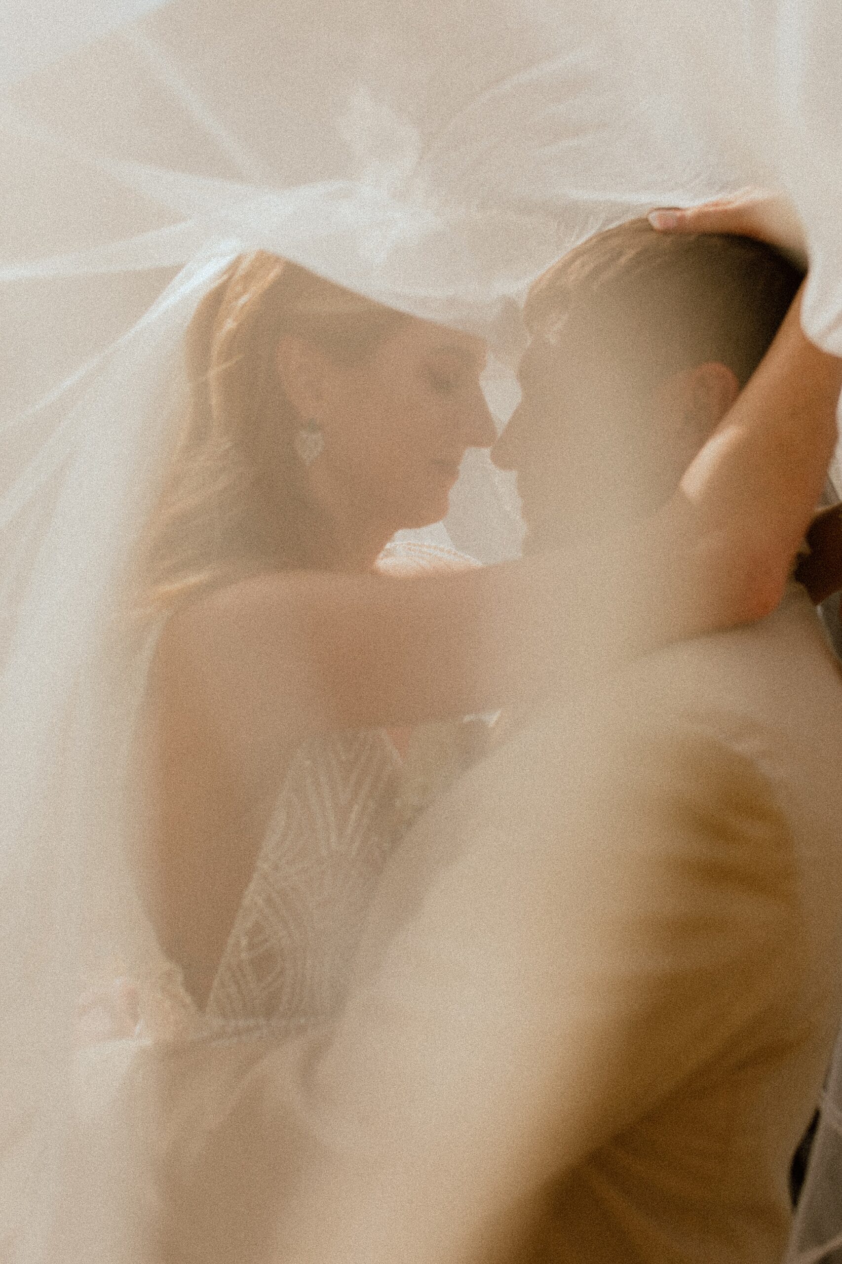 soft focus technique with bride's veil and bride and groom share a moment